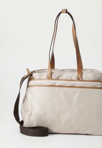 Borsa tote in pelle beige con dettagli in pelle color cuoio, doppie maniglie superiori e tracolla marrone. Dotata di tasca frontale con cerniera. Texture liscia.