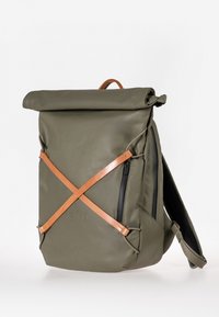 Zaino impermeabile verde oliva con chiusura a rotolo, dettagli in pelle e due cerniere laterali. Presenta un design a strisce geometriche.
