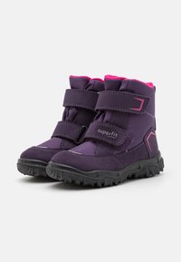 Bottes pour tout-petits de couleur violette avec des accents roses, fabriquées en nylon et en suède. Dotées de sangles Velcro, d'un col rembourré et d'une semelle en caoutchouc texturée.