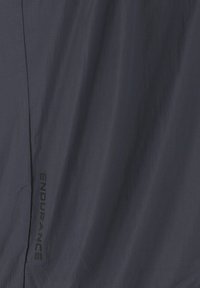 Mörkblå lättvikts tyg, smidig textur med en subtil lyster, har ordet "ENDURANCE" tryckt i svart på den nedre vänstra sidan.