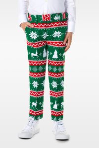 Zaļas brīvdienu bikses ar baltu sniegpārsliņu, koku un briedžu rakstiem ar sarkaniem akcentiem. Pārī ar baltām sporta apaviem.