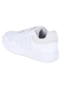 White athletic shoe with a smooth leather upper, perforated accents, and three embossed stripes. Thick rubber sole and padded collar.