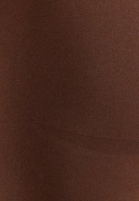 Bruine ribstof met een gladde textuur. Kenmerkt zich door een subtiele glans en een lichte rek, wat zorgt voor een aansluitende uitstraling.
