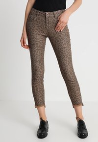 Leopardmönstrade skinny jeans i brunt och svart. Tillverkade av stretchigt material med fyra fickor och fransade nederkanter vid anklarna.