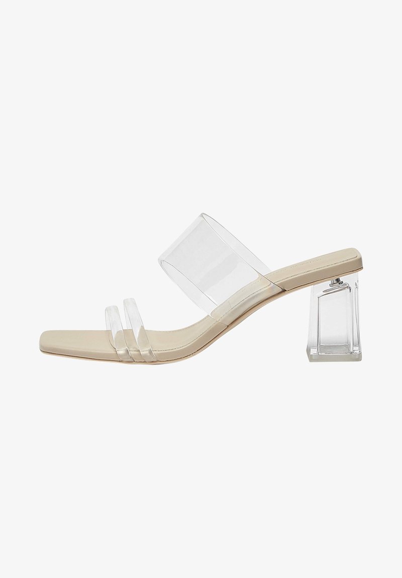 Sandale beige à talon haut ouvert à l’avant avec talon bloc transparent, trois lanières transparentes à l’avant et une large lanière transparente sur le cou-de-pied.