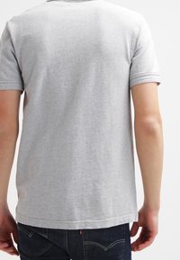 T-shirt grigio a maniche corte con collo rotondo, realizzato in tessuto testurizzato, con orlo dritto e design minimalista.