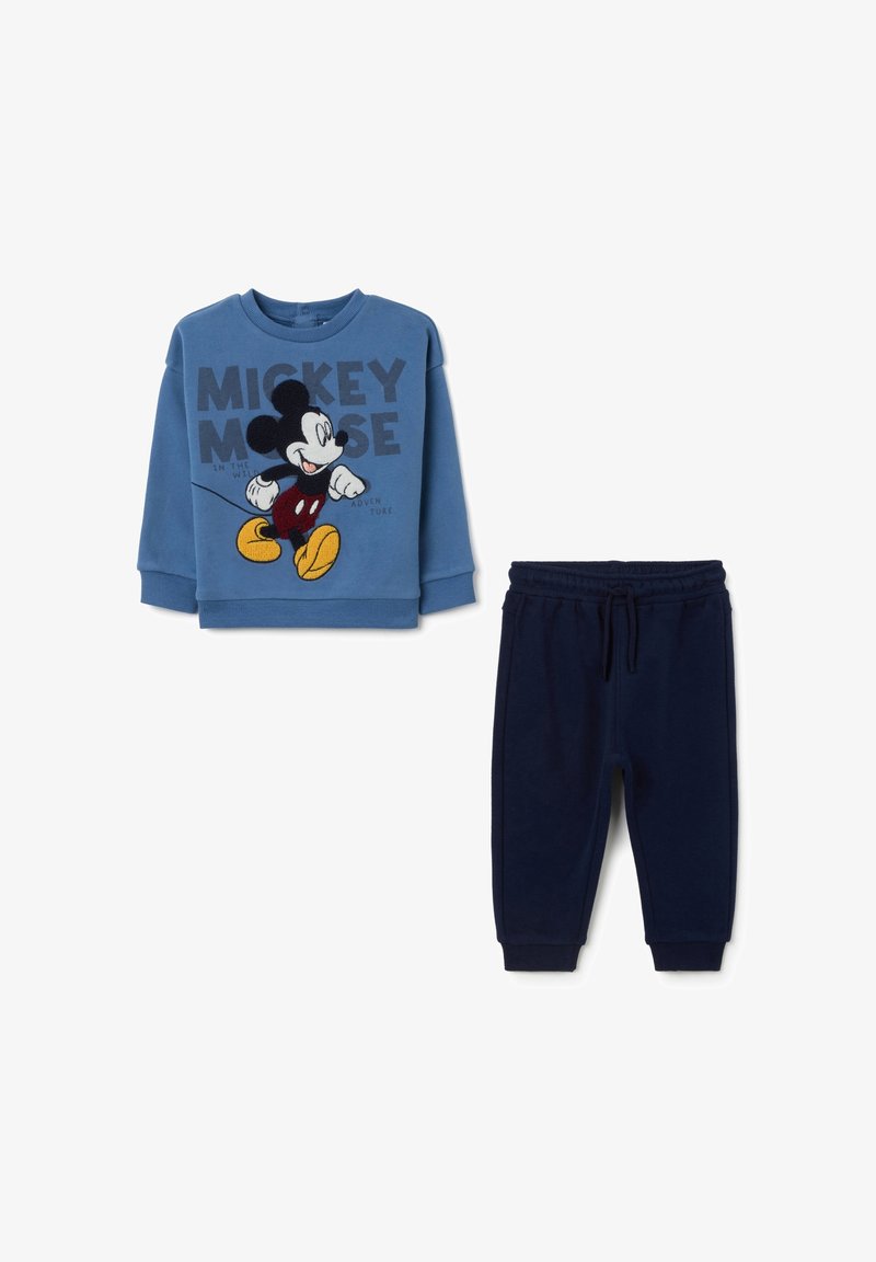 Felpa blu con grafica di Topolino e testo, abbinata a pantaloni della tuta blu scuro. Entrambi sono in tessuto morbido con vita elasticizzata.