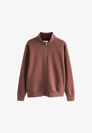 Rjava flis jakna z visokim ovratnikom in pol zadrgo na sprednji strani. Ima dolge rokave in sproščen kroj. Gladka površina.