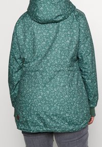 Turquoise hooded jacket with a floral pattern, made of smooth fabric. Features elastic cuffs and a mid-length design with a drawstring hem.