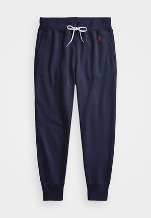 Marineblaue Jogginghose mit weißem Kordelzug, Seitentaschen, gerippten Bündchen und rotem besticktem Logo an der rechten Hüfte.