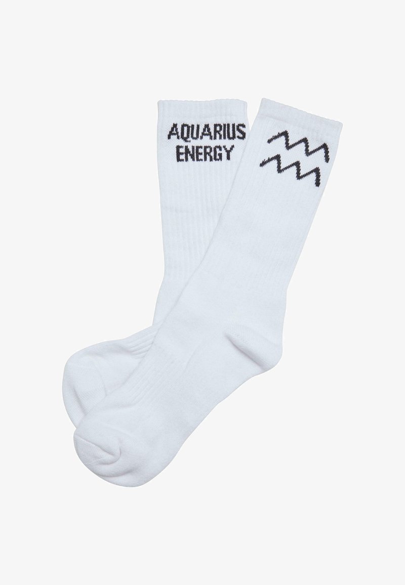 Hvide bomuldsstrømper med ribbet tekstur, der pryder "AQUARIUS ENERGY" i sort skrift og et bølget linjemønster nær toppen.