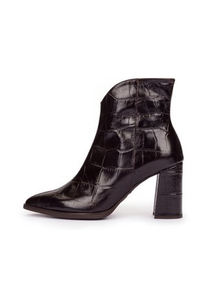 Bota negra brillante hasta el tobillo con textura de piel de cocodrilo y tacón alto ancho sobre fondo blanco.
