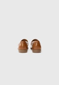 Chaussures en cuir marron au fini lisse, avec un bout arrondi et un petit talon. Présente des détails cousus sur les côtés et à l'arrière.