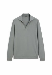 Koszulka polo z długim rękawem w miękkim szarym materiale z kołnierzem na półkosa i prążkowaną fakturą. Posiada luźny krój i mankiety na rękawach.