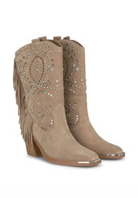 Botines de ante beige con flecos, tachuelas decorativas y acentos azules; puntera afilada y tacón apilado con una tapa metálica.