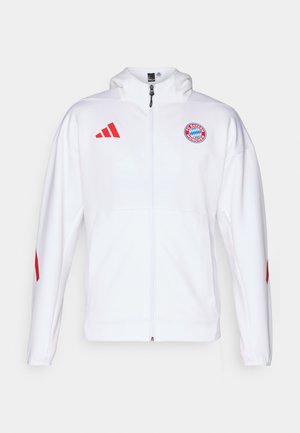 Weiße Jacke mit Reißverschluss und roten Akzenten, mit einem gestickten Logo auf der Brust und dem Adidas-Three-Stripes-Logo auf den Schultern.
