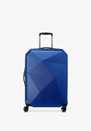 Maleta rígida azul con un diseño geométrico, acabado texturizado, mango retráctil y cuatro ruedas para facilitar la movilidad.