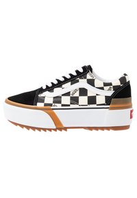 Baskets basses Vans avec motif damier noir et blanc, bande latérale blanche, semelle épaisse blanche et gomme avec bande de roulement texturée.