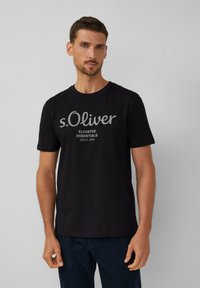 Čierne bavlnené tričko s okrúhlym výstrihom a krátkymi rukávmi, s bledosivým textovým logom na prednej strane s nápisom "s.Oliver Elevated Essentials."