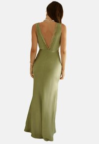 Olivgrünes, ärmelloses Kleid mit tiefem V-Ausschnitt und Spitzenbesatz. Langes, enganliegendes Design mit glatter Textur und ohne sichtbare Muster.