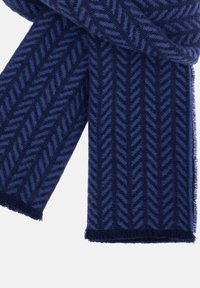 Námořnický modrý šátek vyrobený z texturované tkaniny s rybářským vzorem, s třásněmi na okrajích a jemným povrchem.