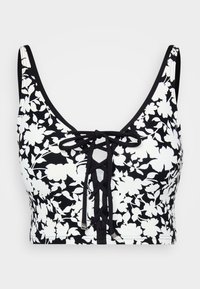 Top corto floreale in bianco e nero con scollatura a barco e dettaglio anteriore con lacci regolabili. Realizzato in tessuto elasticizzato e liscio.