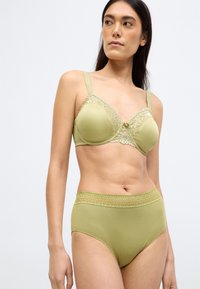 Miękki zielony zestaw bielizny składający się z usztywnianego biustonosza z koronkowymi zdobieniami oraz wysokich majtek ze ściągaczem o scallopowanym wykończeniu.