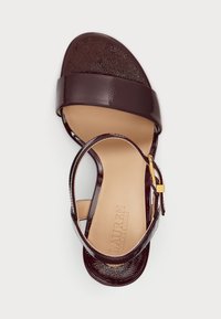 Ανοιχτό μπροστινό σάνταλο σε σκούρο μπορντό ματ δέρμα με λουράκι στον αστράγαλο και χρυσό κούμπωμα, μπεζ πάτος, επίπεδο σόλα.