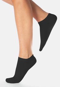 Calcetines negros hasta el tobillo con una textura suave, que presentan un puño acanalado y una forma ajustada, diseñados para quedar justo por encima del tobillo.