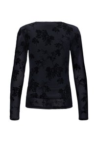 Haut noir transparent à manches longues avec motifs floraux en velours subtils, silhouette ajustée et encolure ronde, vu de dos.
