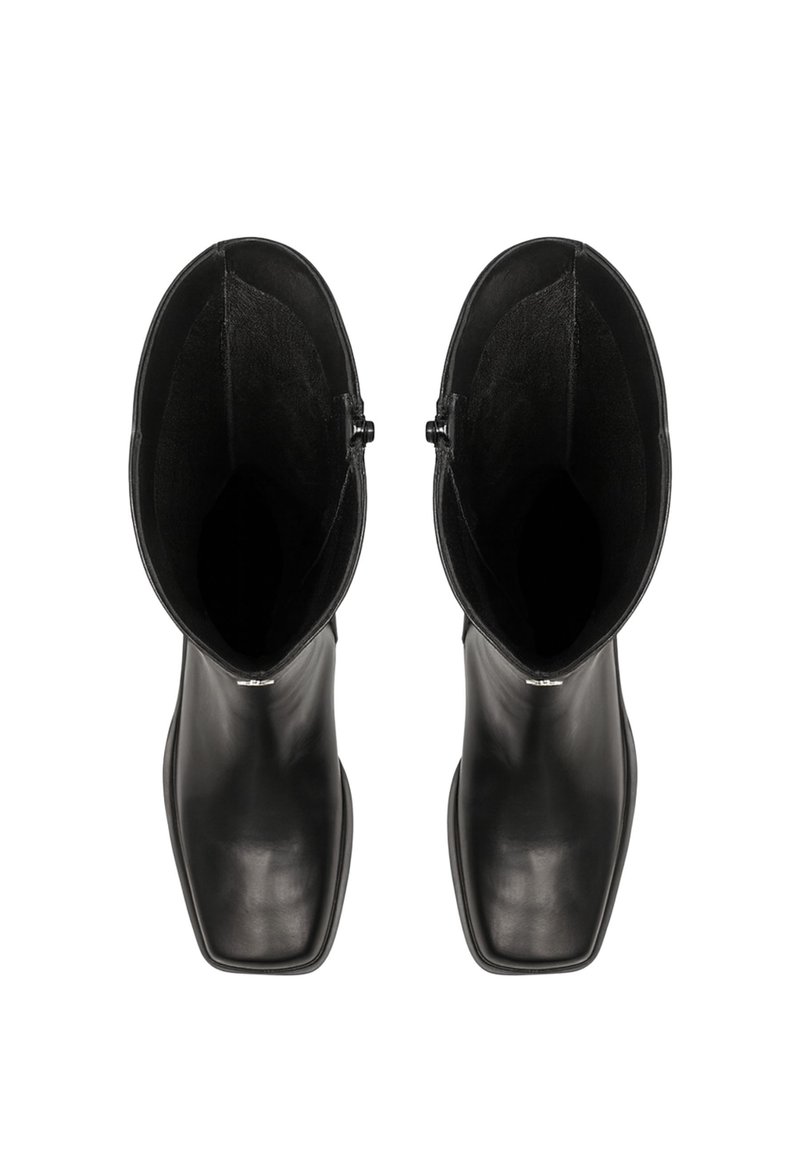 Un paio di stivali neri in pelle con punta quadrata e altezze elevate, visti dall'alto su uno sfondo bianco.