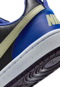 Sneaker Nike con tomaia nera con accenti blu e verdi, pelle testurizzata e suola in gomma bianca con battistrada a motivo.