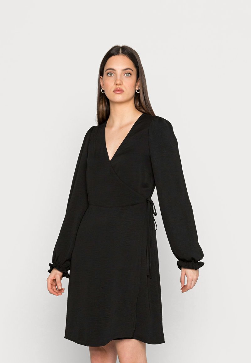 Vestido preto envolvente com mangas longas em balão, decote em V, punhos elásticos e cintura com laço, feito de um tecido texturizado. Barra lisa.