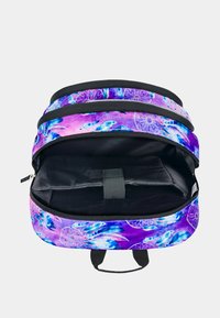 Zaino viola e rosa con motivo floreale, due scomparti, interno nero e un anello in tessuto per il trasporto. Chiusura con cerniera.