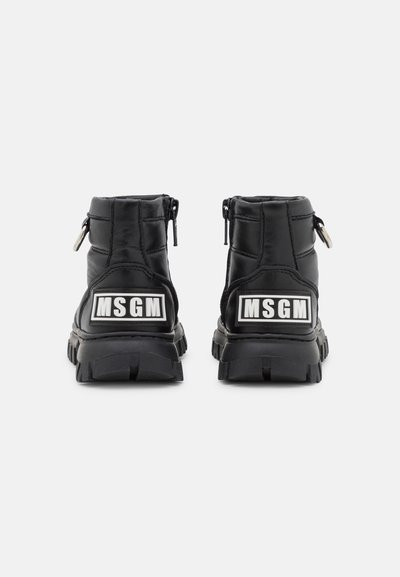 Botas pretas até ao tornozelo com textura acolchoada, apresentando um fecho lateral, sola grossa e um proeminente logótipo branco da MSGM na parte de trás.