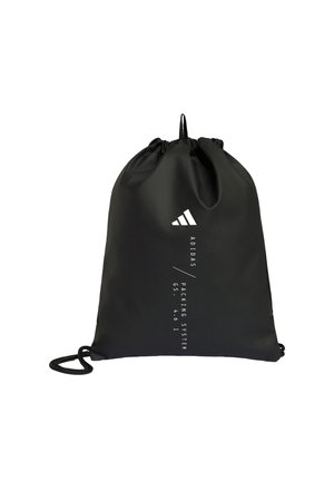 Czarna torba Adidas ze sznurkiem, białym logo i pionowym tekstem "ADIDAS / PACKING SYSTEM" na przodzie.