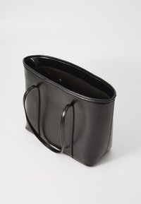 Zwarte leren totebag met twee lange handvatten, rechthoekige vorm, gladde textuur en een open bovenkant die een donkere binnenkant onthult.