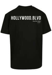 Black cotton T-shirt featuring “HOLLYWOOD.BLVD” in large white font on the back, with “City of Los Angeles” in smaller text below.