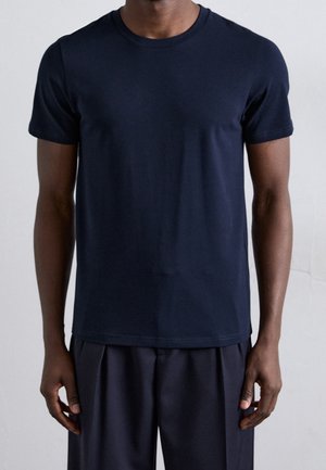T-shirt navy a girocollo realizzato in morbido cotone, caratterizzato da maniche corte e una vestibilità rilassata. Design semplice e senza cuciture, senza modelli visibili.