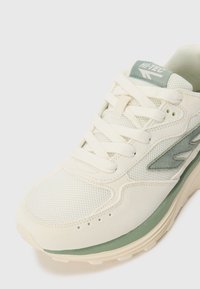 Cream and light green running shoe with mesh and suede texture, rounded toe, lace-up closure, and "Hi-Tec" logo on the tongue and side.