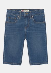 Jeansshorts med en medelblå tvätt, med smal passform, fem fickor och guldfärgad metall. Tydlig sömdetalj genom hela plagget.