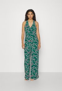 Grønn blomstret jumpsuit med halterneck-design, som har V-hals, vide ben og et lett stoff med rosa detaljer.