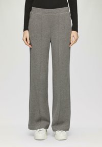 Graue Sweatpants mit einer lockeren Passform, aus weichem Material, mit einem breiten Bund, seitlichen Taschen und vertikalen Nähten für eine strukturierte Optik.
