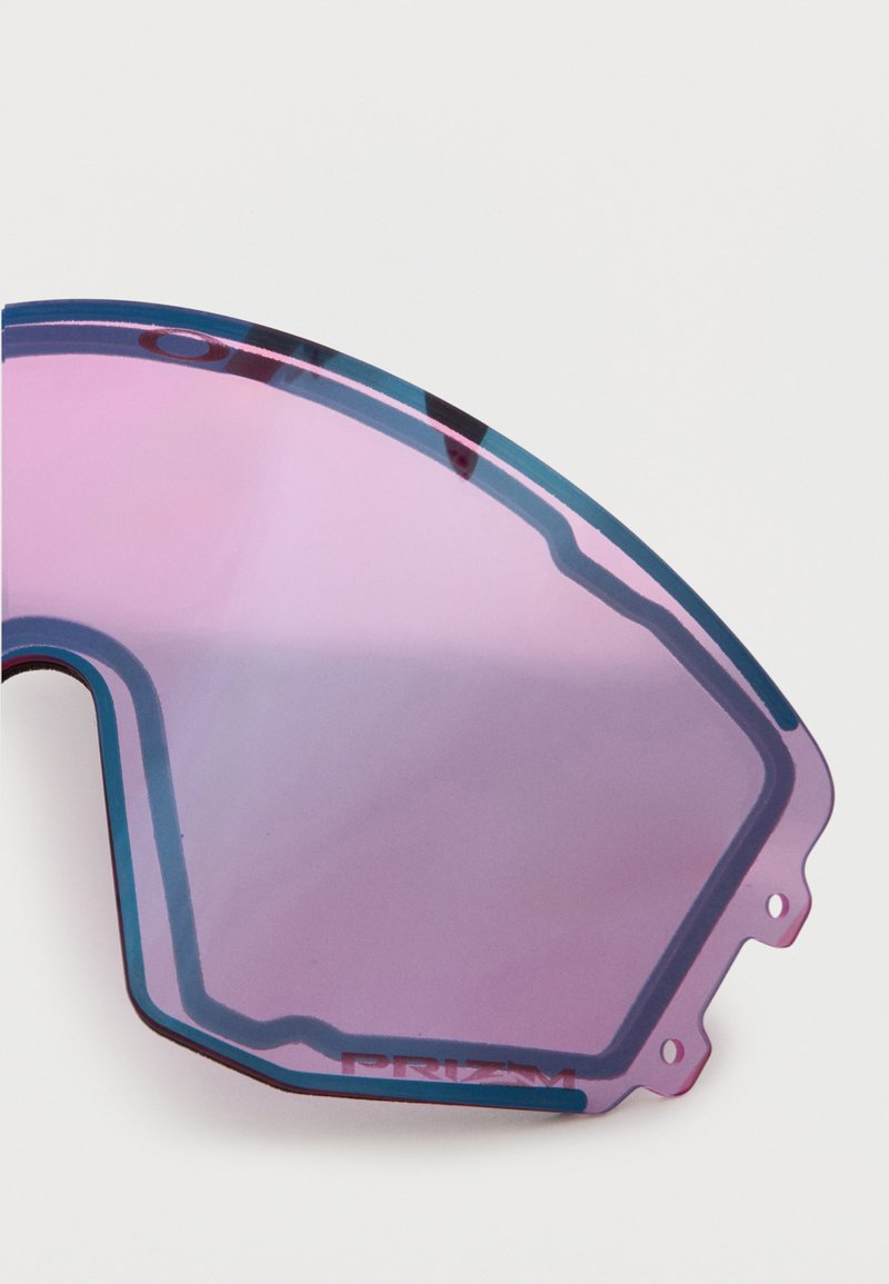 Close-up van een paars getinte, hoekige vervangingslens voor sportzonnebrillen met "PRIZM" geëtst nabij de rand.