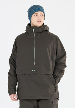 Dunkelgrauer Pullover-Jacke mit einem halben Reißverschluss vorne, Kapuze und einer aufgesetzten Tasche, aus wasserabweisendem Material, kombiniert mit einer blauen Mütze.