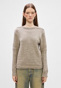 Beige knit sweater with textured sleeve accents, ribbed cuffs, and a crew neck. Features a relaxed fit and a smooth, lightweight fabric.