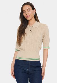 Beige short-sleeve sweater with a collared neck, featuring vertical ribbed texture, three buttons, and green striped accents at the cuffs and hem.