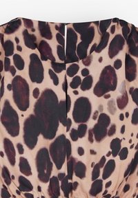 Blouse met luipaardpatroon en ronde hals, met donkerbruine en zwarte vlekken op een lichte beige achtergrond, gatherend bij de taille.