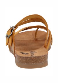 Sandaľ s hnedou korkovou stielkou a koženými popruhmi v horčicovo-žltej farbe s kovovou sponou. Dizajn obsahuje prekrížené popruhy pre bezpečné uchytenie.