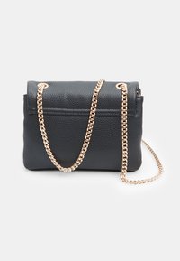 Borsa a tracolla in pelle nera con texture, dotata di pattina piegata e una catena dorata. Presenta un interno liscio e un design minimalista.
